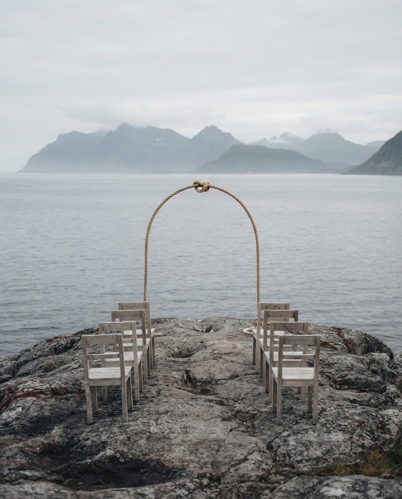 Artist's impression of rows of wooden chairs on a bare rock facing a rope arch, with grey sea and mountains beyond, no people